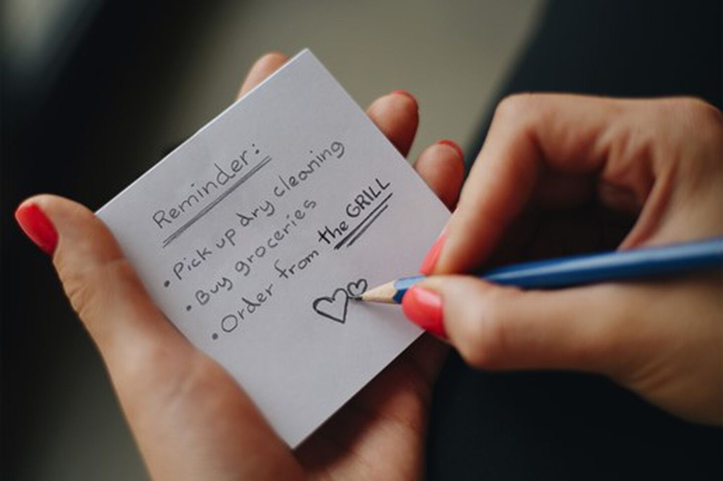 Hands with post-it with reminders to order from The Grill