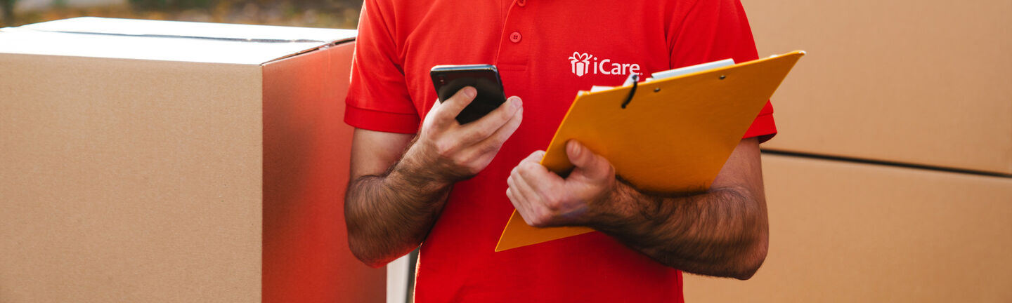 iCare delivery person holding clipboard & phone